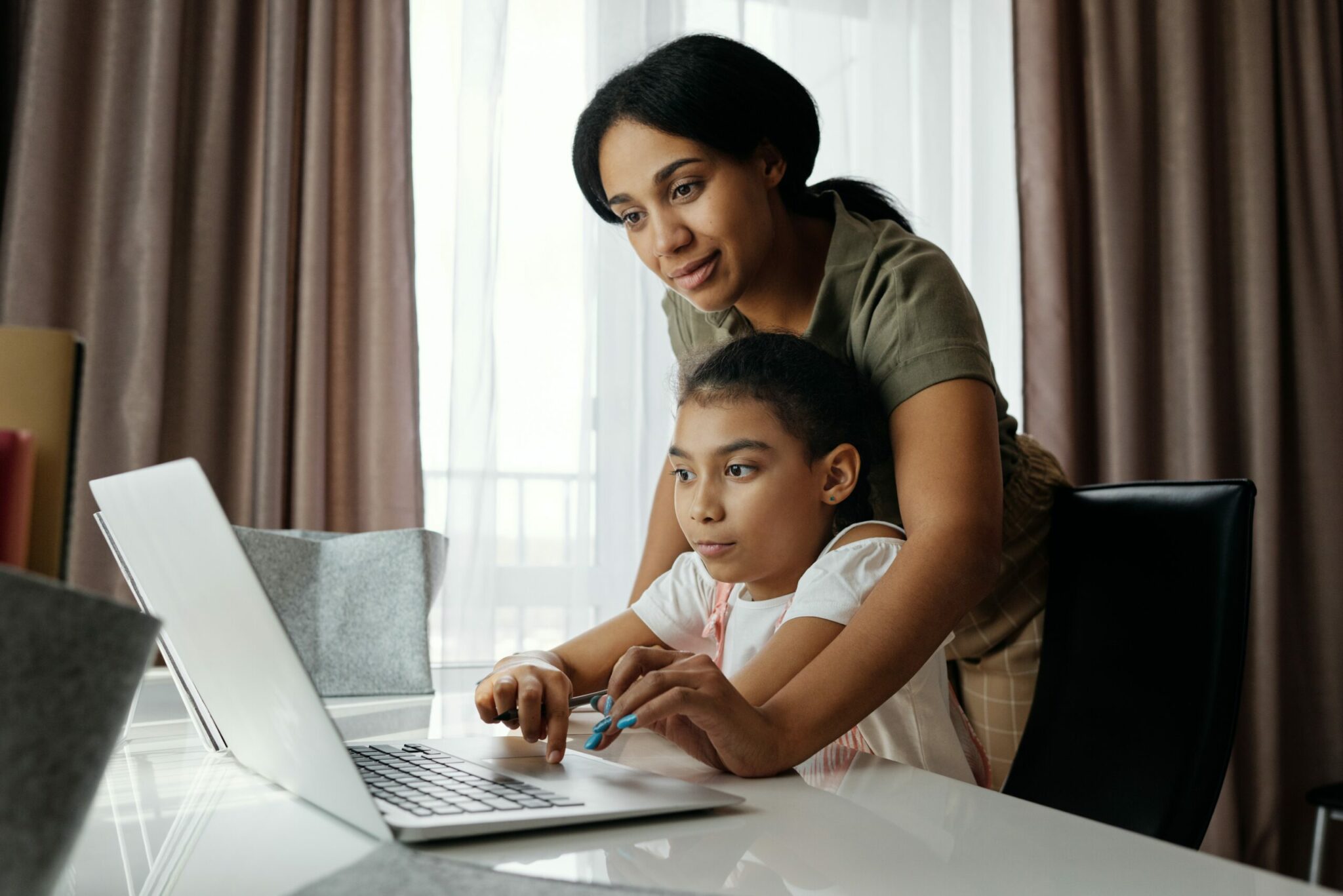 Mum and daughter looking at laptop together